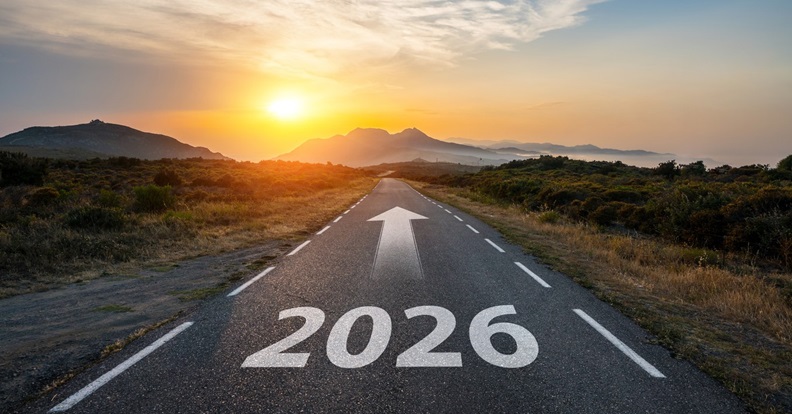 Egyenes országút ‘2026’ felirattal és előre mutató nyíllal naplementében.