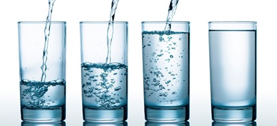 Négy pohár víz különböző töltöttségi szintekkel, egymás mellett sorban.