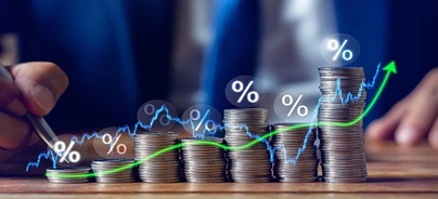 Érmékből emelkedő oszlopsor látható, felette százalékjelekkel és egy felfelé tartó zöld vonallal, a hozamok növekedését jelképezve.