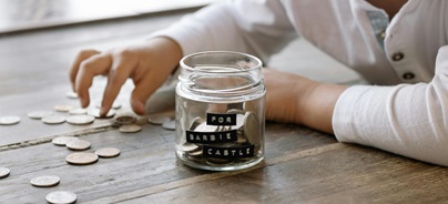 Két ember pénzügyi grafikonokat elemez egy laptop képernyőjén és egy papírlapon, amely kördiagramot és oszlopdiagramot mutat.