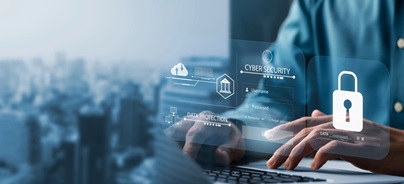 Laptopon dolgozó személy előtt lebegő digitális kiberbiztonsági elemek, lakat ikon és bejelentkezési felület, adatvédelem témában.
